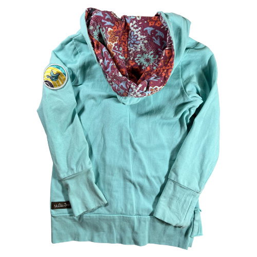 Pre-Owned Hooded Jacket Brand: Matilda Jane Size: Little girl size 6 Color: Turquois with shades of purple and orange florals Features: Long sleeves, zip-up, lined hood, ruffles, soft material, decorative patch on sleeve Material: 95% Cotton, 5% Spandex Condition: Gently used, good condition. Minor sains at the end of cuffs and sleeve. Online thrift store - Our Families Attic