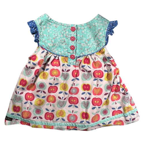 Pre-owned Matilda Jane Lucia Shabby Apple Top for little girls, size 6, featuring a light multicolor design with apple and floral prints, cap ruffle sleeves, button closure at the back, and ribbon trim, available at Our Families Attic.