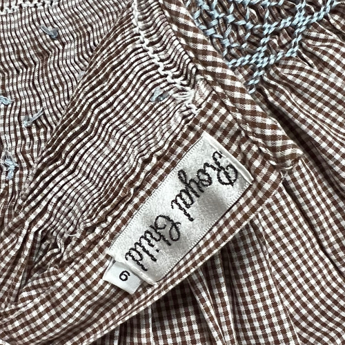 Pre-owned Royal Child Brown & White Gingham Smocked Dress for little girls, size 6, featuring puff sleeves, blue stitched smocking on the neckline, and a classic gingham pattern, available at Our Families Attic.