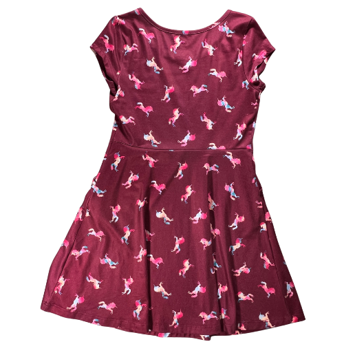 Pre-Owned dark red unicorn print dress for big girls, size 7, by SO, available at Our Families Attic. Features colorful unicorn patterns, cap sleeves, and pockets in the skirt. Gently used and perfect for playful occasions.