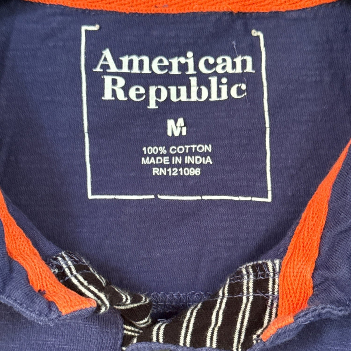 American Republic men’s size Medium polo label showing 100 percent cotton fabric content