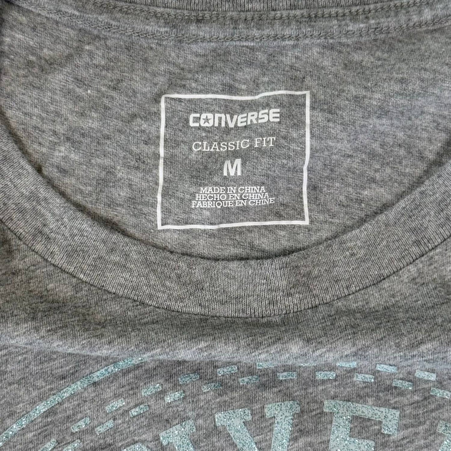Turquoise glitter Converse logo close up on gray shirt
