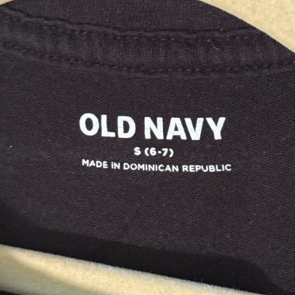 Old Navy girls clothing label showing size Small 6–7 inside black Halloween T-shirt.