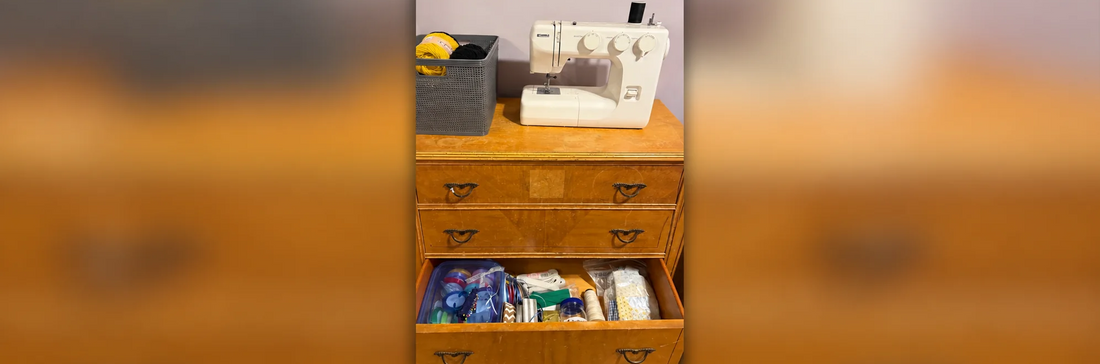 Papa’s vintage wooden dresser repurposed for craft storage, topped with a Kenmore sewing machine and yarn basket, with an open drawer of sewing supplies.