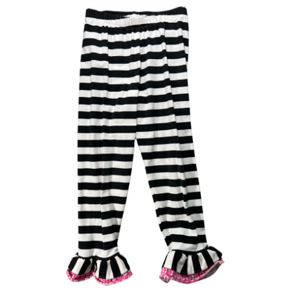 Pre-owned Counting Daisies dress in black, white, and pink with a floral pattern, paired with black and white striped leggings. The dress features cap sleeves, a lace trim, a fabric floral accent, and an attached tie belt. The leggings have an elastic waistband and ruffled hems. Size 6, gently used condition. Shop www.ourfamiliesatticcom 