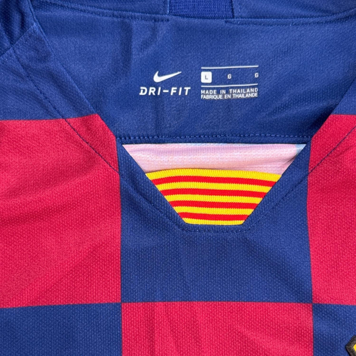 Close-up of Nike Dri-FIT men’s Large neck marking and striped collar insert on FC Barcelona jersey