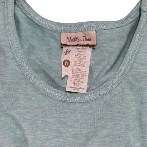 Close-up of a green shirt with a Matilda Jane label on a white background