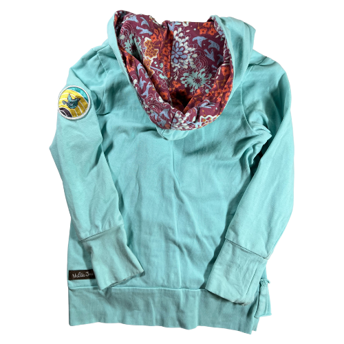 Pre-Owned Hooded Jacket Brand: Matilda Jane Size: Little girl size 6 Color: Turquois with shades of purple and orange florals Features: Long sleeves, zip-up, lined hood, ruffles, soft material, decorative patch on sleeve Material:  95% Cotton, 5% Spandex Condition:  Gently used, good condition. Minor sains at the end of cuffs and sleeve. Online thrift store - Our Families Attic