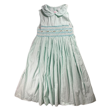 Mint green dress with smocked bodice on a white background
