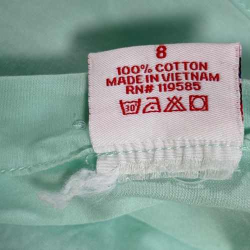 Fabric tag with text on a light green fabric background