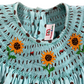 Pre-owned Mom & Me Aqua Smocked Dress with Brown Polka Dots for little girls, size 6X, featuring rickrack trim on the shoulder ruffle, sunflower embroidery, and a 4-button closure, available at Our Families Attic.