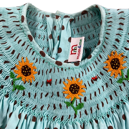 Pre-owned Mom & Me Aqua Smocked Dress with Brown Polka Dots for little girls, size 6X, featuring rickrack trim on the shoulder ruffle, sunflower embroidery, and a 4-button closure, available at Our Families Attic.