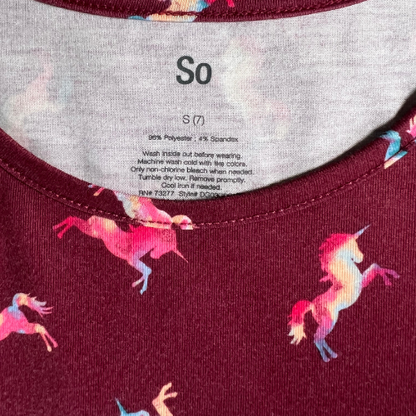Pre-Owned dark red unicorn print dress for big girls, size 7, by SO, available at Our Families Attic. Features colorful unicorn patterns, cap sleeves, and pockets in the skirt. Gently used and perfect for playful occasions.