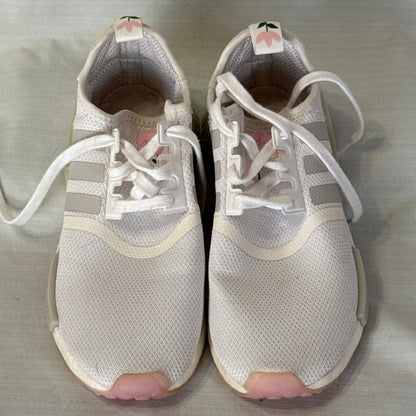 Front view of white Adidas NMD_R1 sneakers with white laces, gray stripes, and pink toe accents.