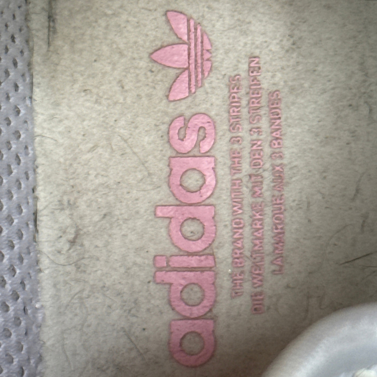 Close-up of the shoe interior showing pink Adidas lettering and Trefoil branding.