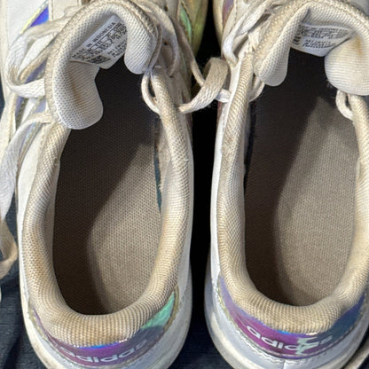 Interior view of white Adidas sneakers showing fabric lining, insoles, and visible discoloration.
