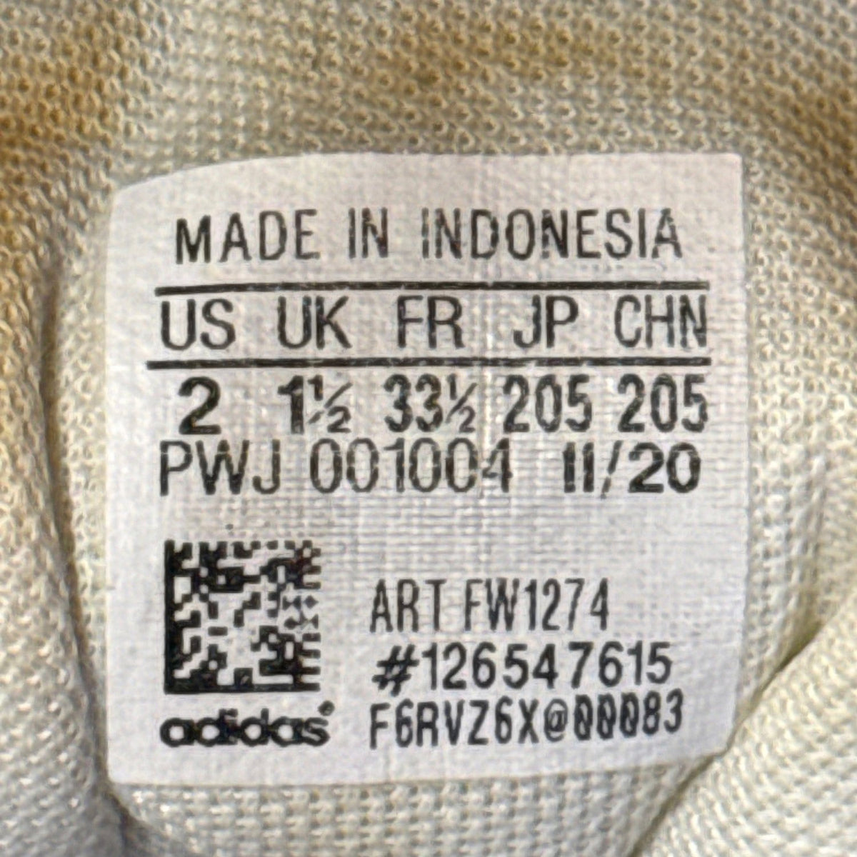 Adidas sneaker size label showing US 2, UK 1.5, and FR 33.5.
