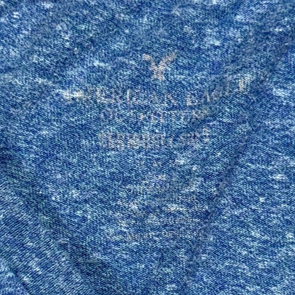 Close-up of heather blue fabric with a faded American Eagle brand logo.