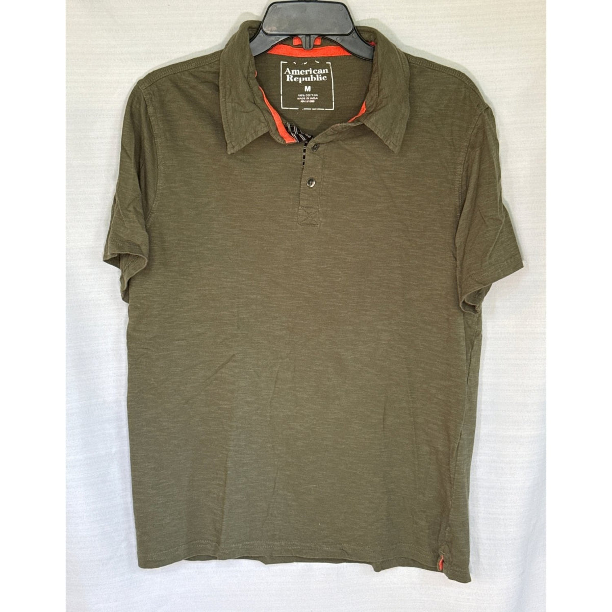 Front of American Republic men’s medium olive green short-sleeve cotton polo with orange and striped placket accents