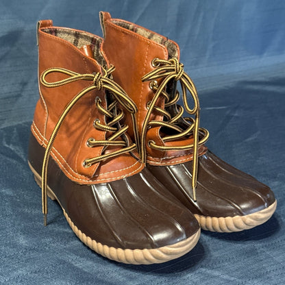 Front angled view of ANNA brown duck boots with metal lace eyelets and cream contrast stitching.