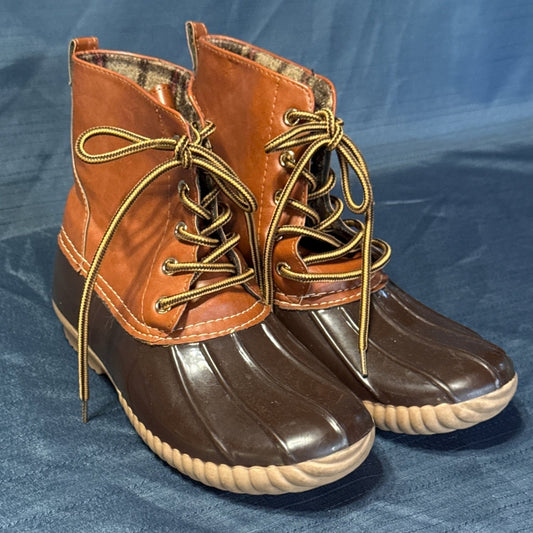 Front angled view of ANNA brown duck boots with metal lace eyelets and cream contrast stitching.
