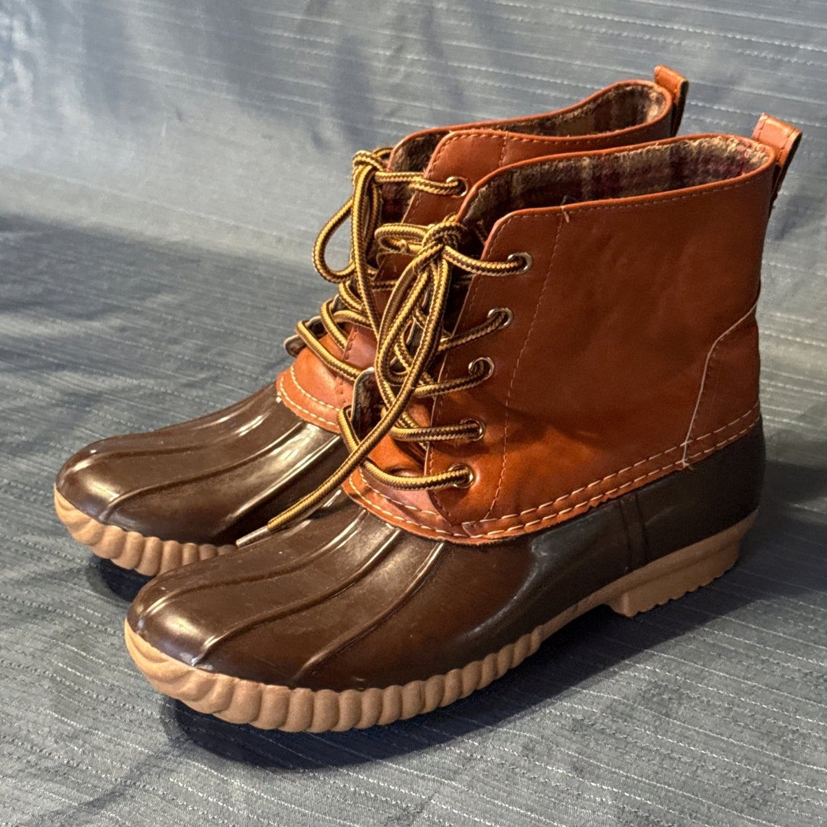Front angled view of ANNA brown duck boots with metal lace eyelets and cream contrast stitching.