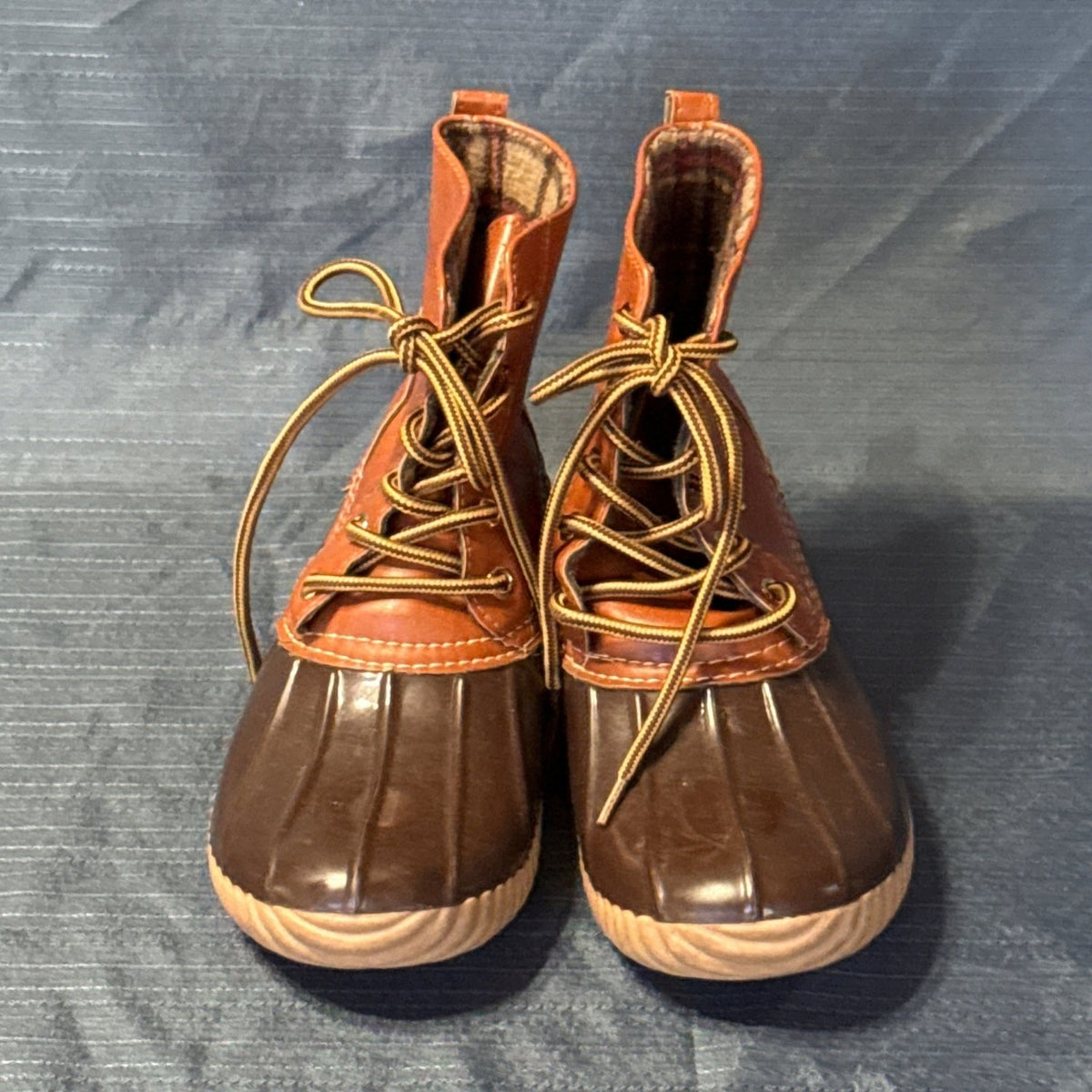Front view of both ANNA brown duck boots showing tied laces and ribbed rubber toes.