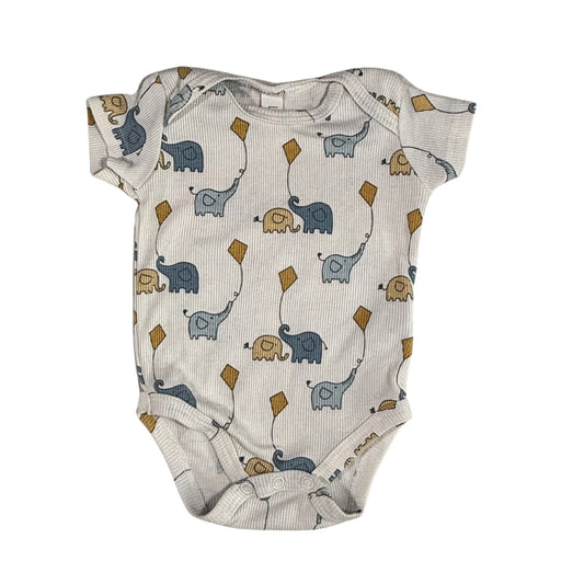 Baby onesie with elephant and kite pattern on a cream background