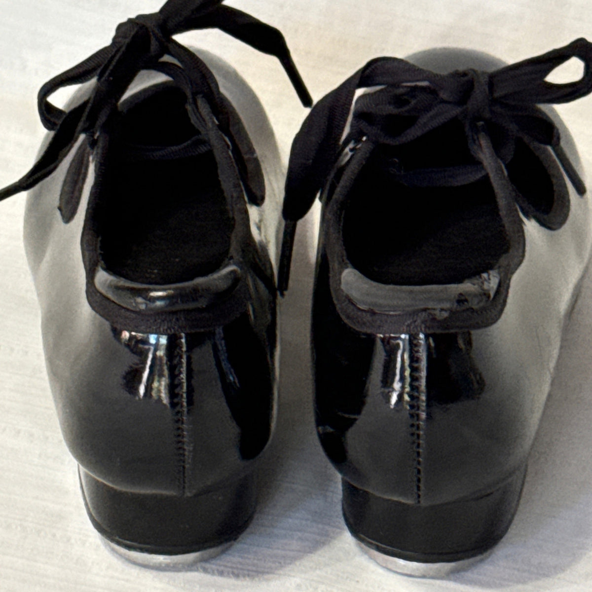 Close-up of peeling black coating at the back heel opening of a Balera tap shoe.
