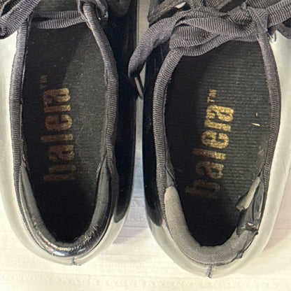 Overhead close-up of Balera tap shoes showing worn insoles and peeling around the heel openings.
