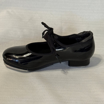 Side profile of a glossy black Balera tap shoe with a round toe, bow tie, and low heel.
