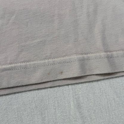 Small stains on front bottom hem of beige t-shirt