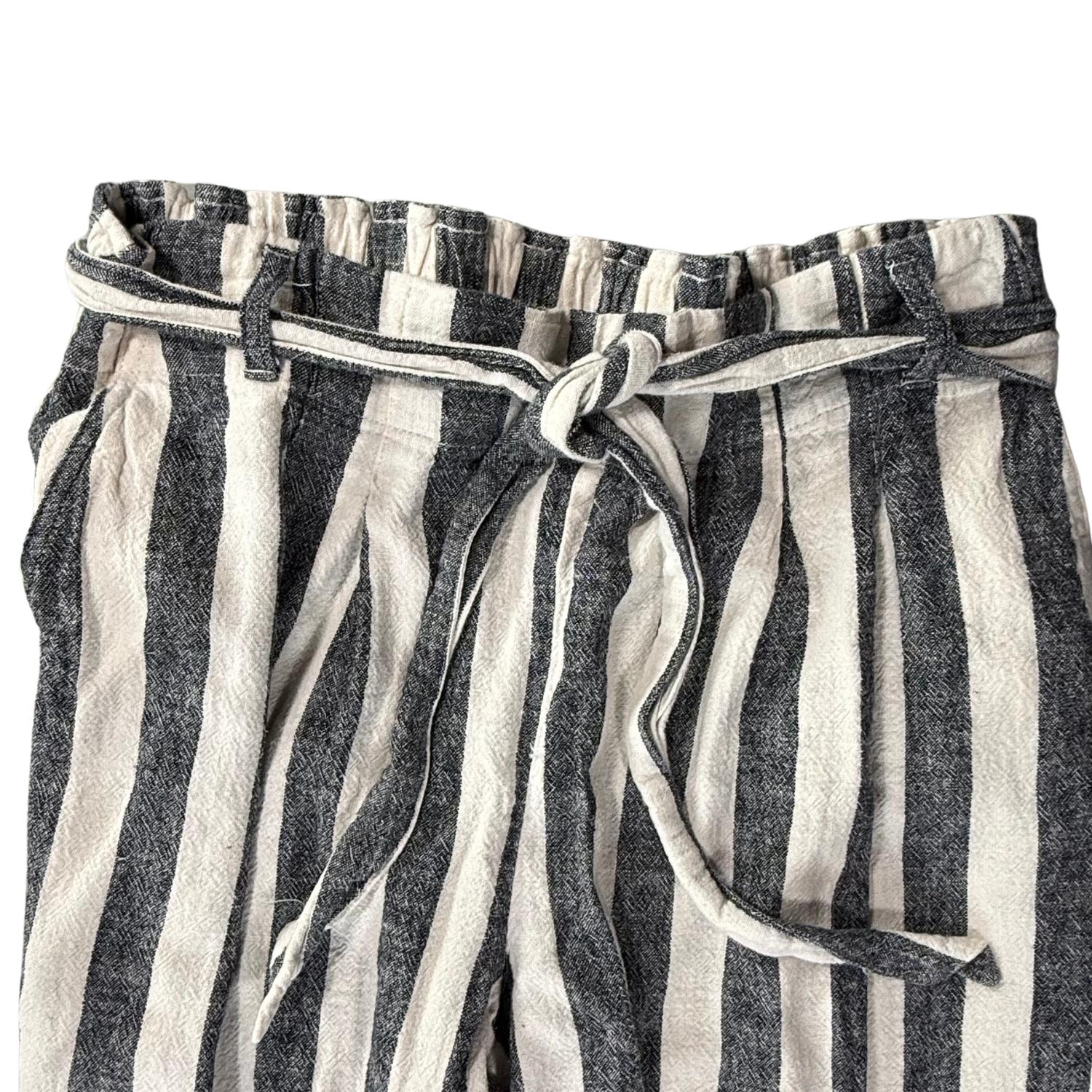 Pink clothing tag with clover leaf gold stitching on striped linen pants