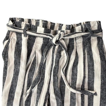 Pink clothing tag with clover leaf gold stitching on striped linen pants