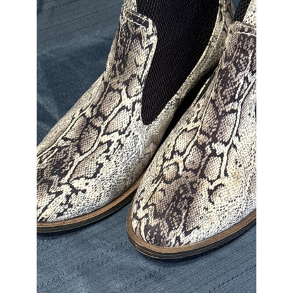 Close-up of the snakeskin-patterned uppers and black elastic side panels on Corkys ankle boots.
