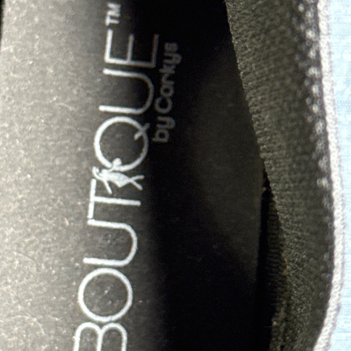 Close-up of the black insole showing Boutique by Corkys branding inside a snake-print ankle boot.
