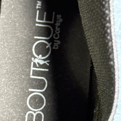 Close-up of the black insole showing Boutique by Corkys branding inside a snake-print ankle boot.
