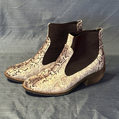 Left-side angled view of black-and-tan snake-print ankle boots with almond toes and elastic side panels.
