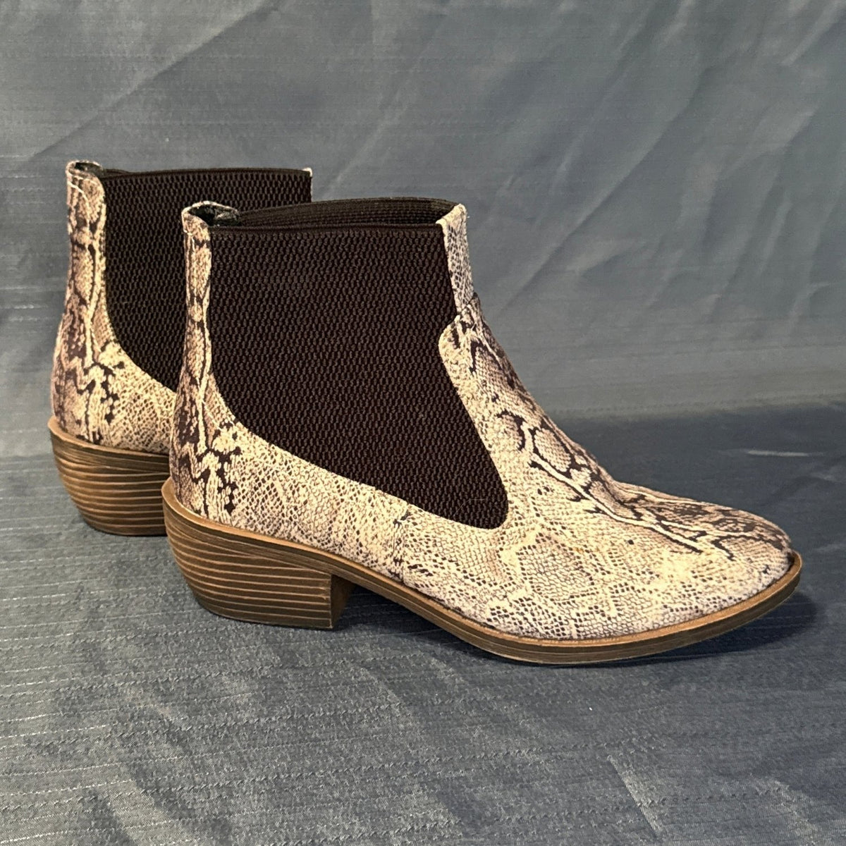 Right-side view of snake-print Chelsea ankle boots showing wide black elastic panels and brown block heels.
