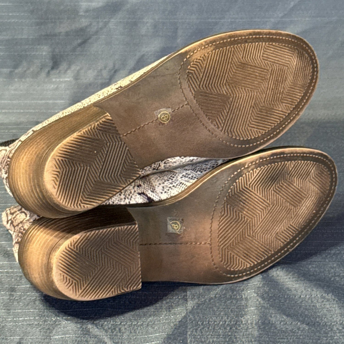 Bottom view of Corkys ankle boots showing brown patterned soles, block heels, and size 8 stickers.
