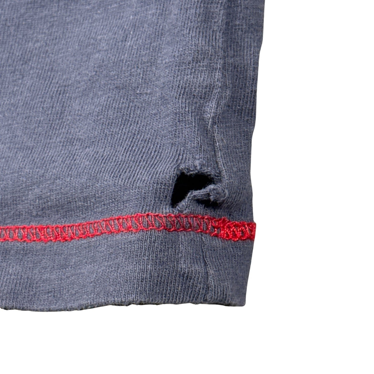 Close-up of small hole near the front hem of the Old Navy boys’ size 5T Santa shirt.