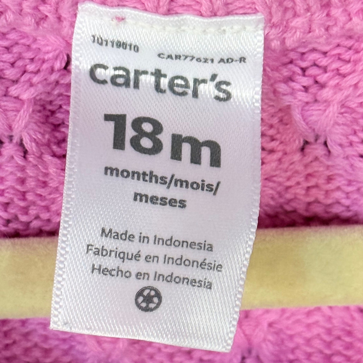 Carter's clothing label showing size 18 months on a pink baby girls textured knit sweater dress.