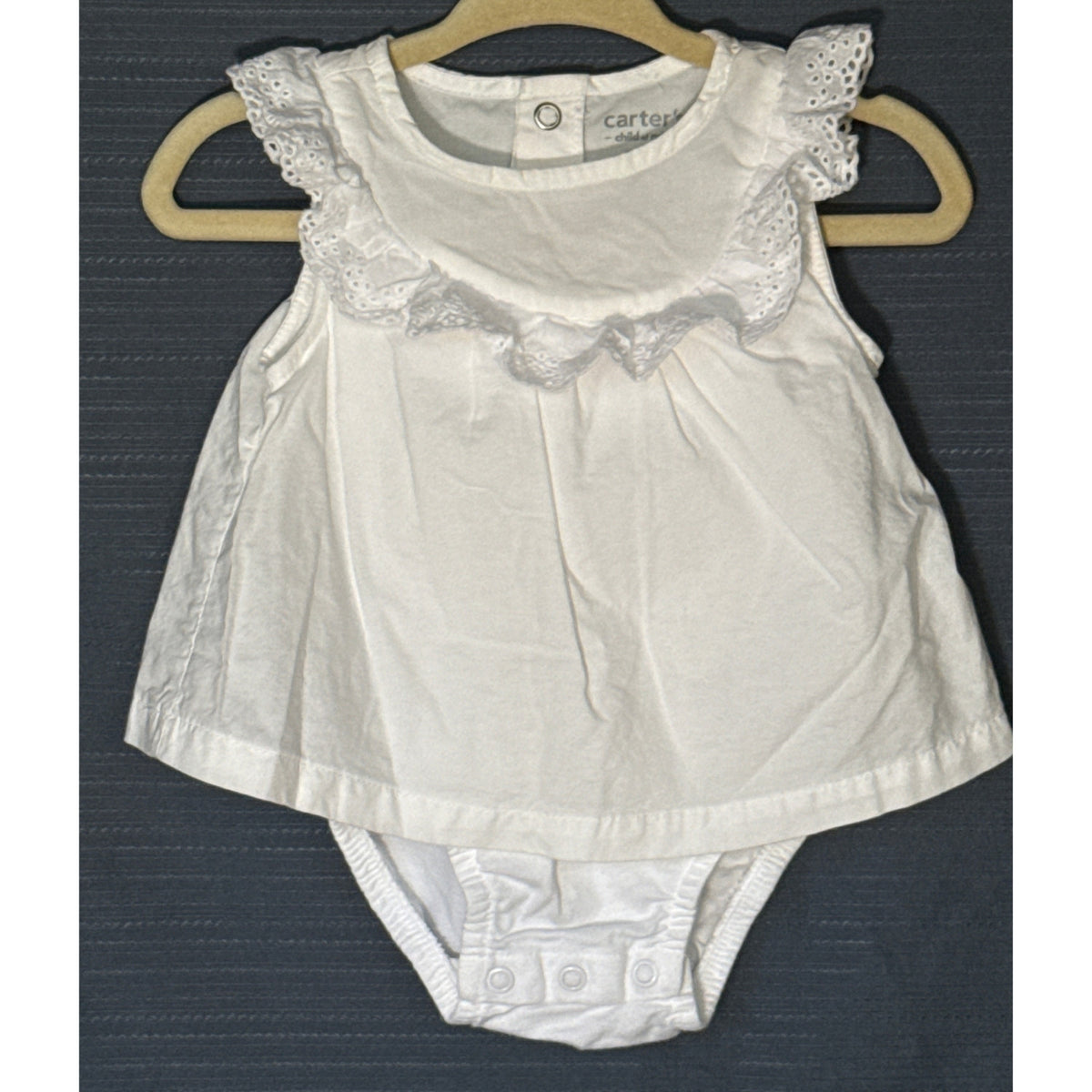 Front view of Carter's Child of Mine white cotton baby girls' bodysuit dress with eyelet ruffle trim and three-snap crotch closure.