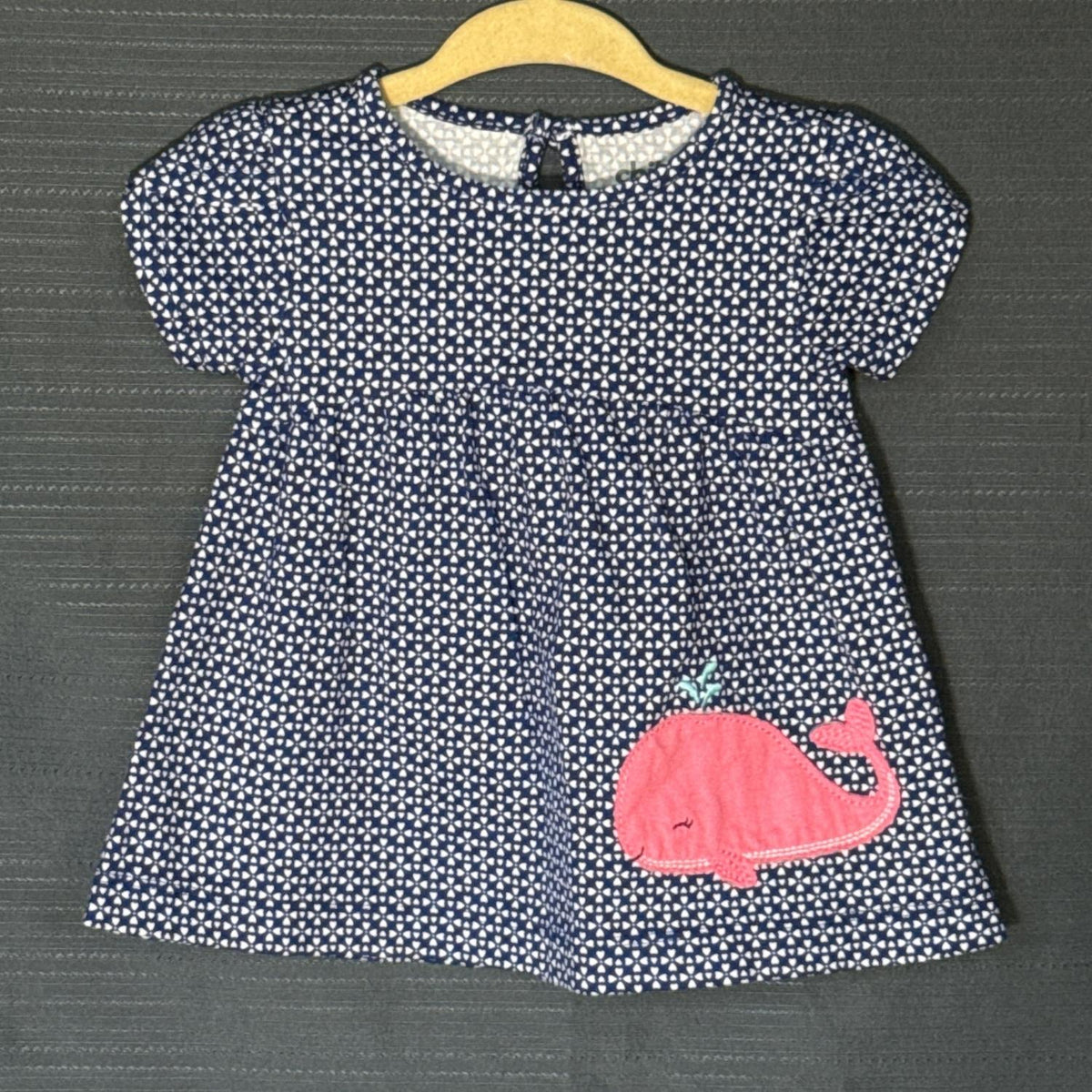 Front view of Carter's Child of Mine baby girls dress with navy blue and white heart print, gathered skirt, and pink whale appliqué.