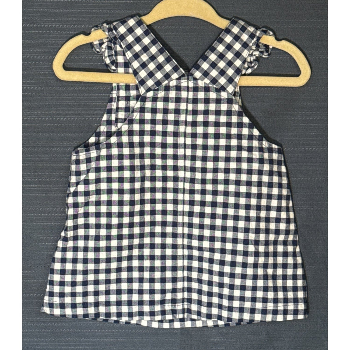 Back view of Carter's Child of Mine navy blue and white gingham baby girls' dress with crossed shoulder straps and ruffle details.