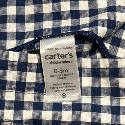 Carter's Child of Mine clothing label showing baby size 0–3 months inside navy blue and white gingham dress.