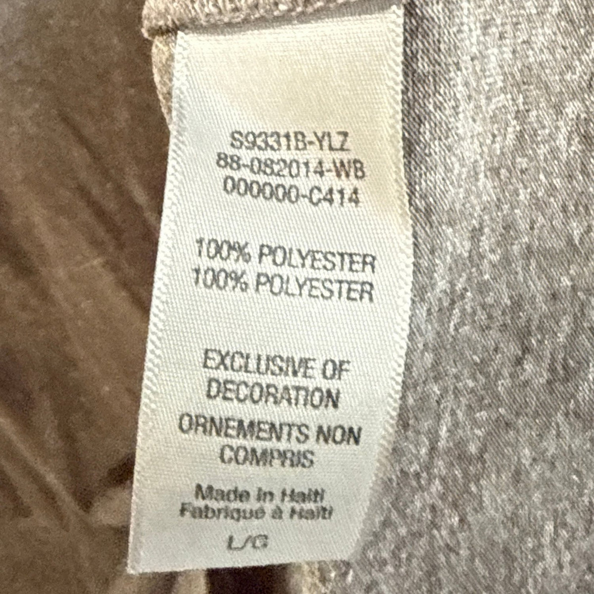 Champion shirt fabric label showing 100% polyester, size large, and made in Haiti.