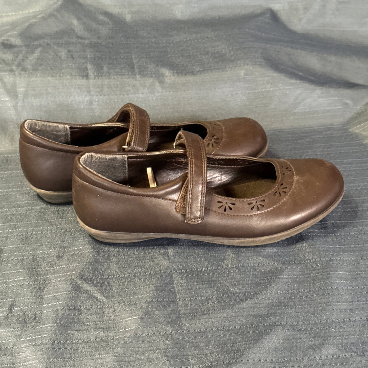 Side view of The Children’s Place brown Mary Janes showing strap closures and low-profile soles.