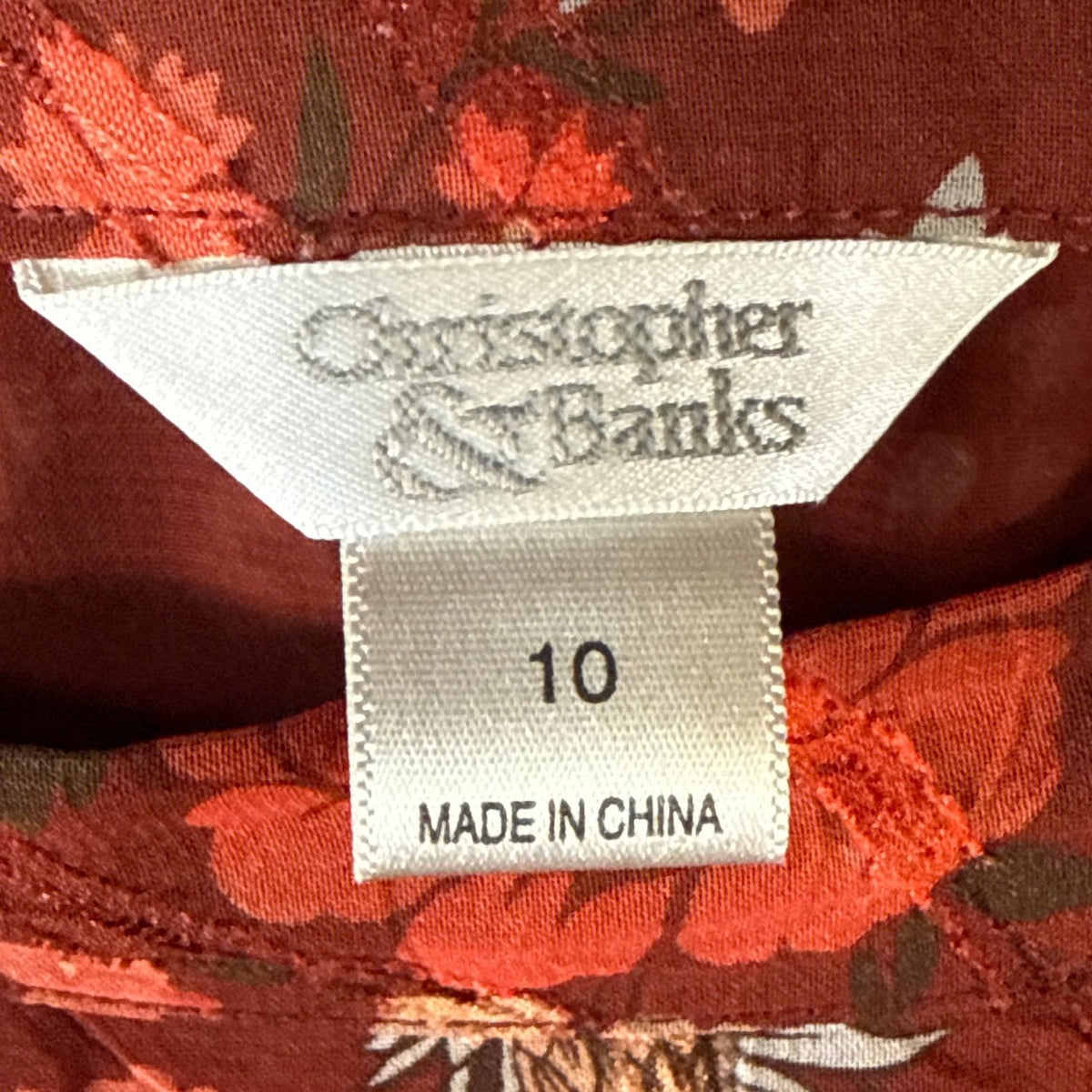 Close-up of Christopher & Banks clothing label showing size 10 inside dark red floral print skirt.
SEO