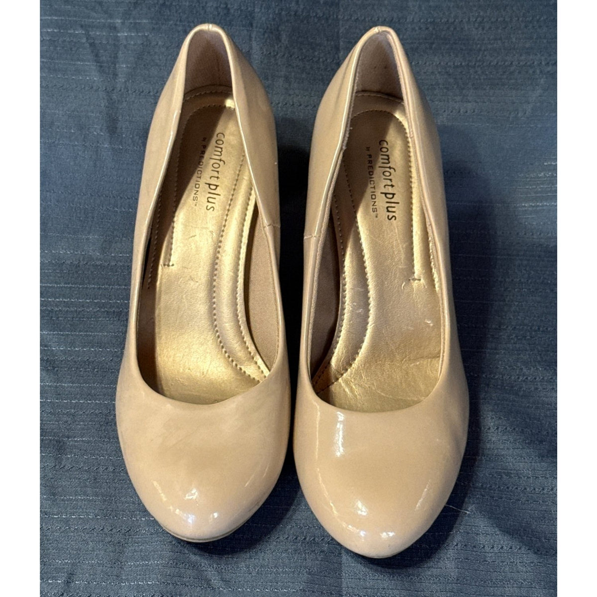 Front view of Comfort Plus by Predictions beige pumps showing rounded toes, glossy uppers, and worn insoles.